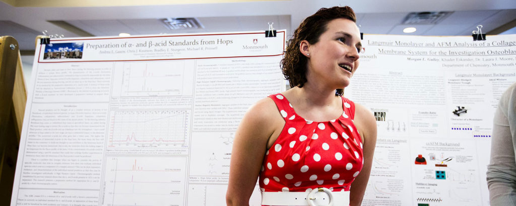 A student presents her research at a poster session.